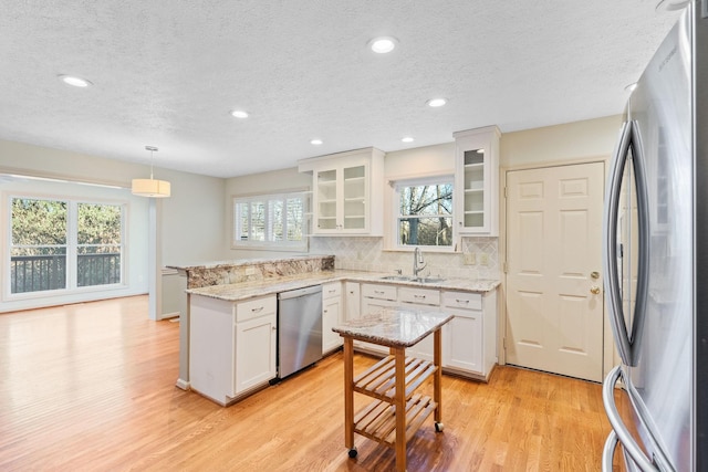 kitchen featuring sink, white cabinets, pendant lighting, and stainless steel appliances