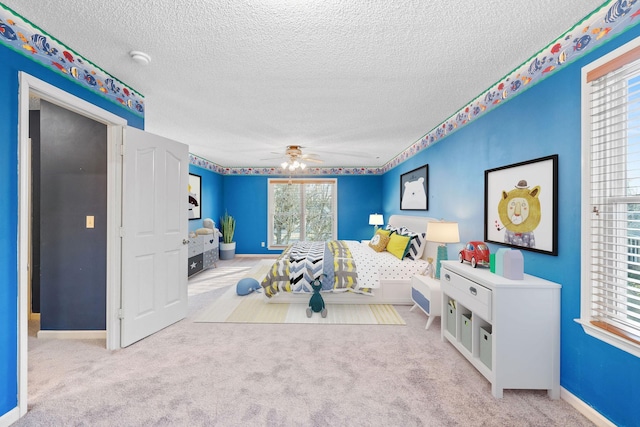 bedroom featuring ceiling fan, light colored carpet, and a textured ceiling