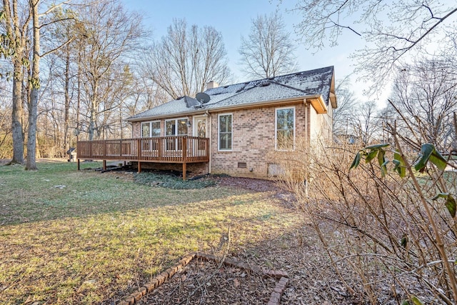 back of property featuring a wooden deck and a yard