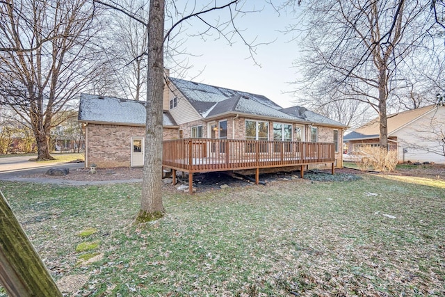 back of house with a deck and a lawn