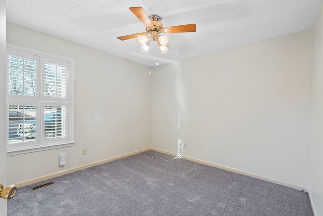 carpeted spare room featuring a textured ceiling and ceiling fan