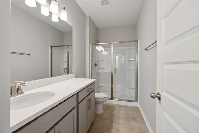 bathroom with vanity, a shower with shower door, tile patterned floors, and toilet