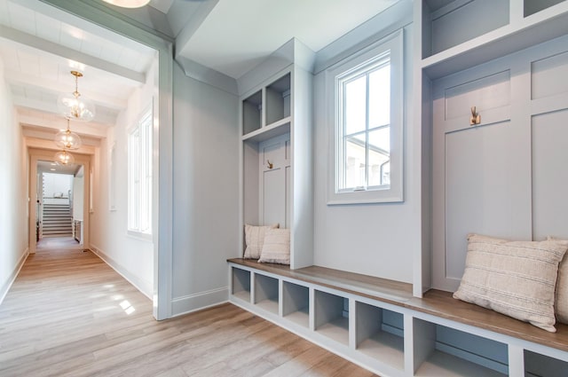 mudroom featuring beam ceiling, a chandelier, and light wood-type flooring