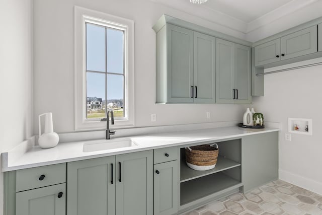 laundry area with cabinets, sink, ornamental molding, hookup for a washing machine, and light tile patterned flooring