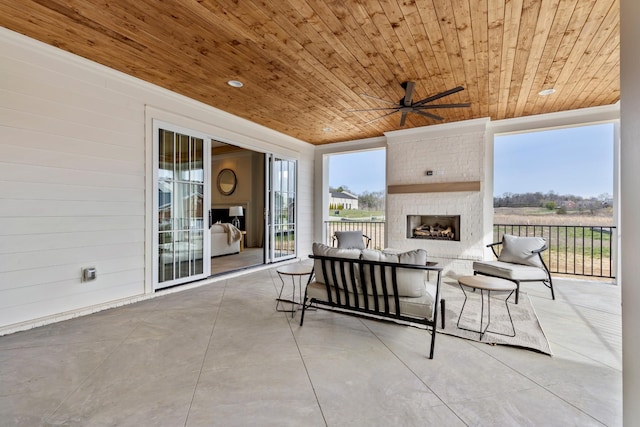 view of patio / terrace with an outdoor living space with a fireplace and ceiling fan