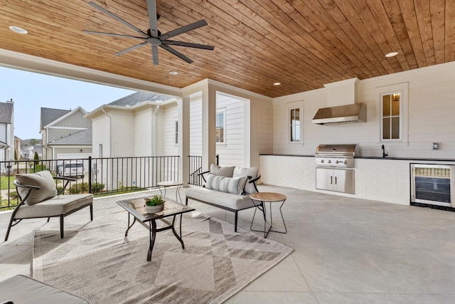 view of patio / terrace featuring exterior kitchen, a grill, wine cooler, ceiling fan, and an outdoor living space