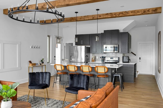 living room with sink, beamed ceiling, and light wood-type flooring