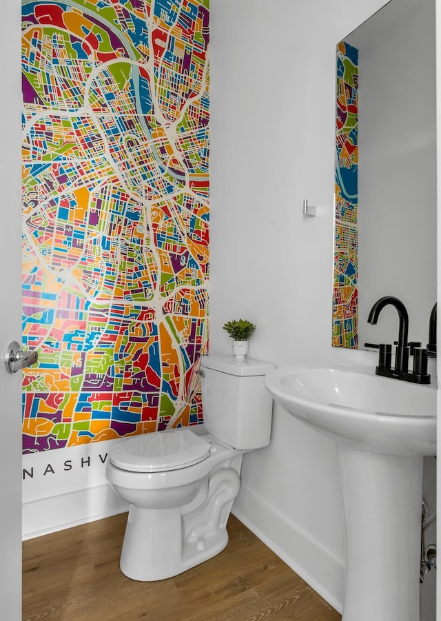 bathroom with hardwood / wood-style flooring and toilet