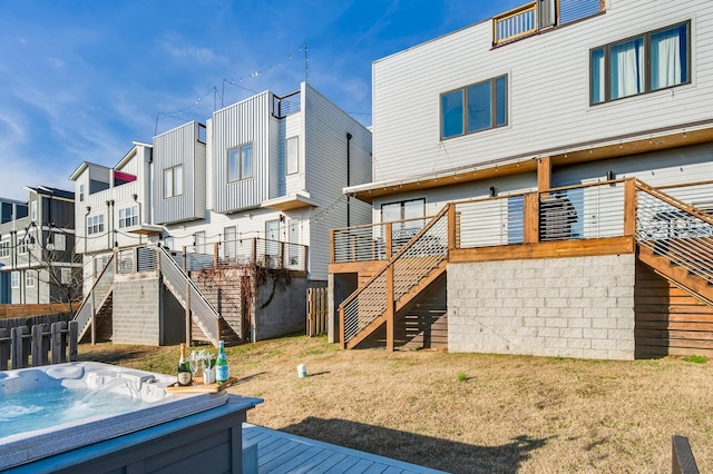 rear view of house with a hot tub and a deck