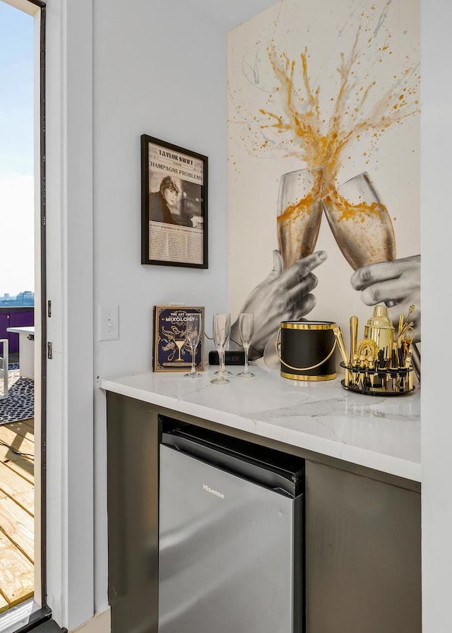 bar featuring plenty of natural light and stainless steel fridge