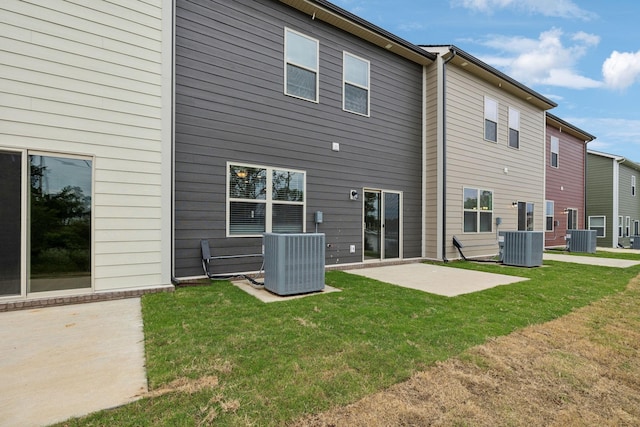 back of house featuring a lawn, a patio, and central AC