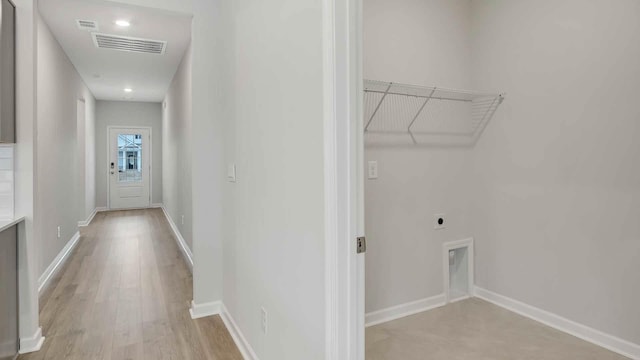 clothes washing area with electric dryer hookup and light hardwood / wood-style floors