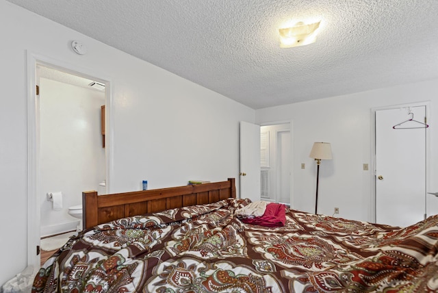 bedroom featuring a textured ceiling and connected bathroom