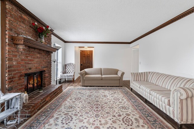 living room featuring a textured ceiling, dark hardwood / wood-style floors, crown molding, and a fireplace