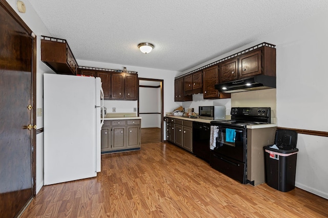 kitchen featuring black appliances, a textured ceiling, light hardwood / wood-style floors, and dark brown cabinetry