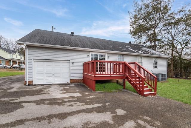 back of property featuring a garage, central AC unit, a yard, and a deck