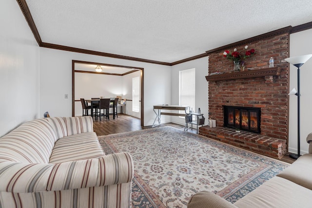 living room featuring a fireplace, hardwood / wood-style floors, a textured ceiling, and ornamental molding