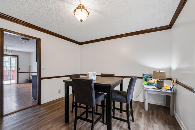 dining space with dark wood-type flooring and a textured ceiling