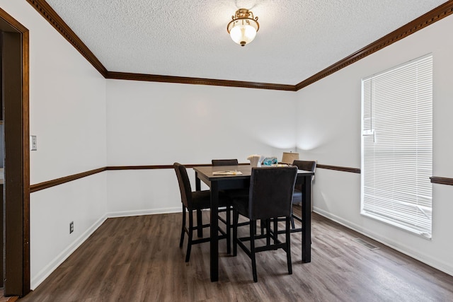 dining room featuring a textured ceiling, dark hardwood / wood-style flooring, and ornamental molding