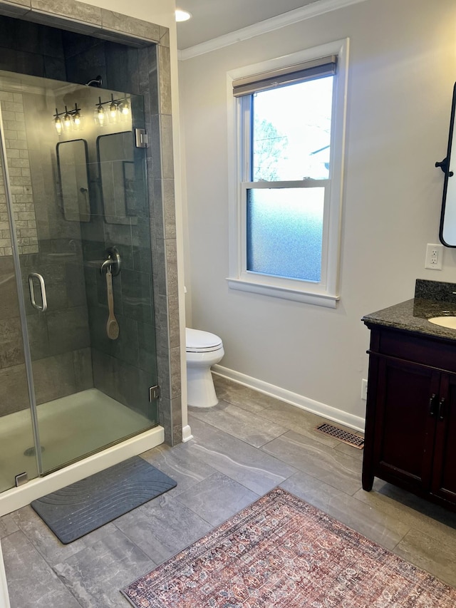 bathroom with a shower with door, toilet, vanity, and crown molding