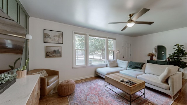 living room featuring crown molding, ceiling fan, and dark hardwood / wood-style flooring