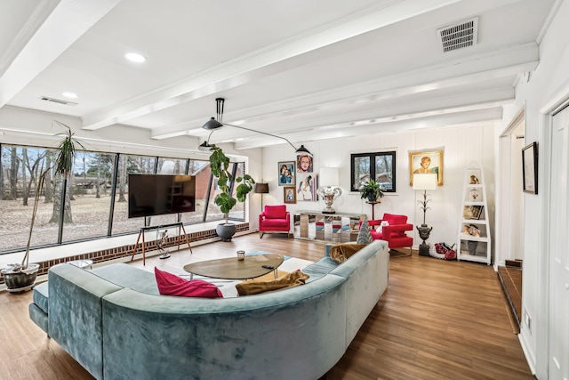 living room featuring a wealth of natural light, beam ceiling, and hardwood / wood-style floors