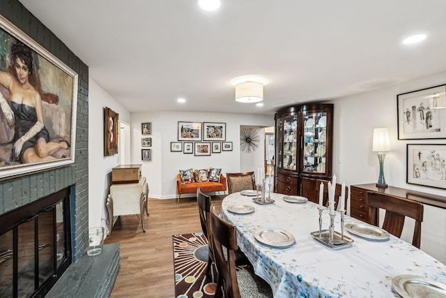 dining space with a fireplace and light hardwood / wood-style flooring