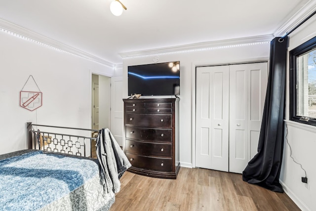 bedroom with crown molding, light hardwood / wood-style floors, and a closet