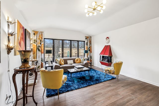 living room featuring a notable chandelier, wood-type flooring, and lofted ceiling