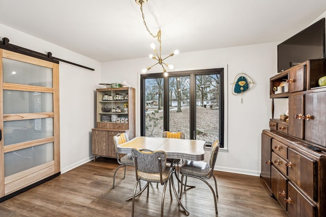 dining area featuring a chandelier, dark hardwood / wood-style floors, and a barn door