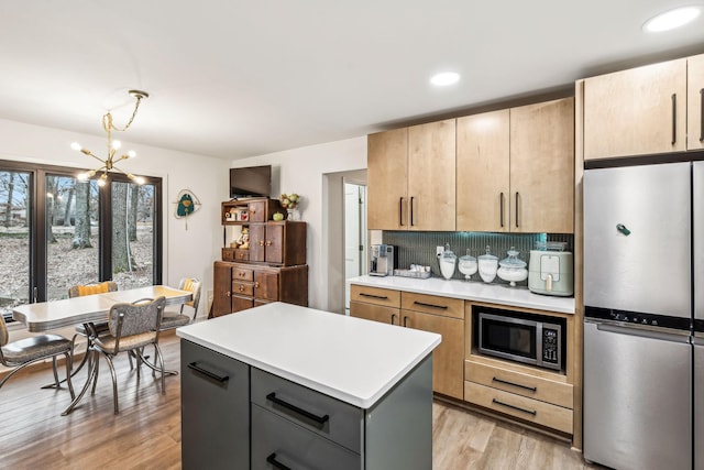 kitchen featuring hanging light fixtures, tasteful backsplash, gray cabinetry, a kitchen island, and stainless steel appliances