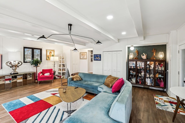 living room featuring beamed ceiling and dark hardwood / wood-style flooring