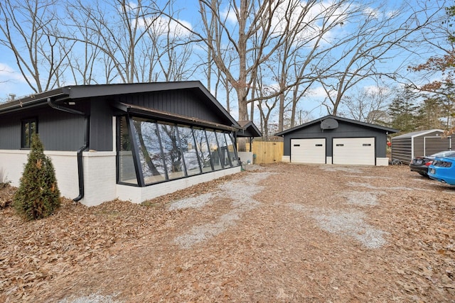 view of home's exterior featuring an outbuilding, a garage, and a sunroom