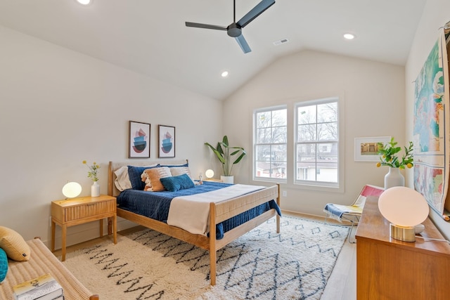 bedroom with ceiling fan, light hardwood / wood-style flooring, and vaulted ceiling