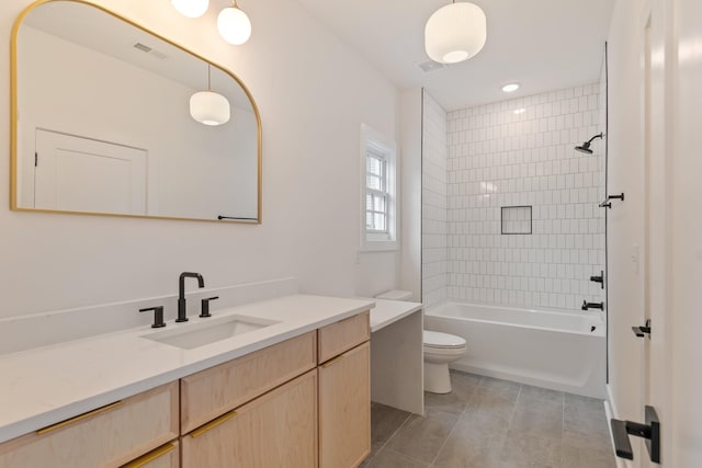 full bathroom featuring tile patterned floors, toilet, vanity, and tiled shower / bath combo