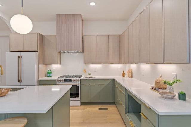 kitchen with light hardwood / wood-style floors, hanging light fixtures, green cabinets, high end white fridge, and stainless steel range with gas cooktop