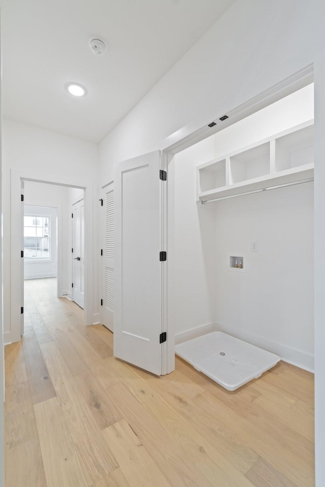 clothes washing area with washer hookup and light hardwood / wood-style flooring