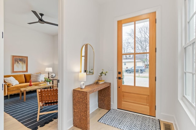 doorway with ceiling fan and light wood-type flooring