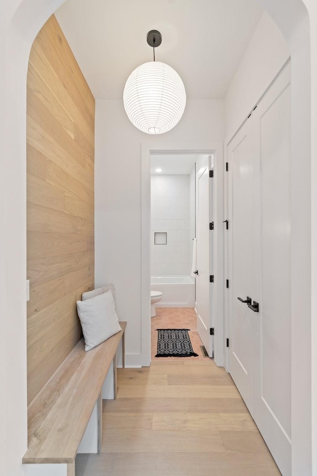 mudroom with light hardwood / wood-style flooring and wood walls