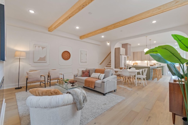 living room featuring light wood-type flooring and beam ceiling