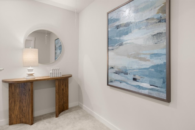 hallway featuring light colored carpet