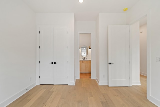 unfurnished bedroom with light wood-type flooring and a closet