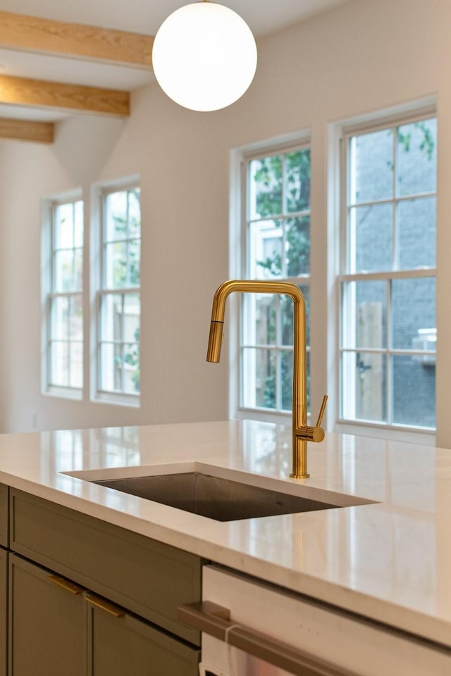 kitchen with sink, gray cabinets, beam ceiling, and dishwasher