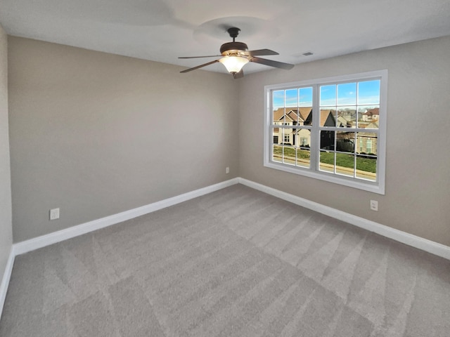 carpeted spare room with ceiling fan