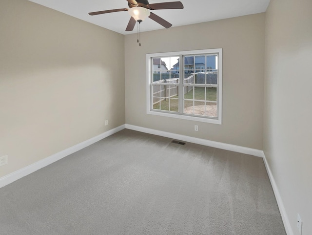 empty room featuring ceiling fan and carpet