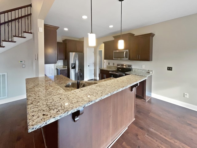 kitchen featuring sink, decorative light fixtures, kitchen peninsula, and appliances with stainless steel finishes