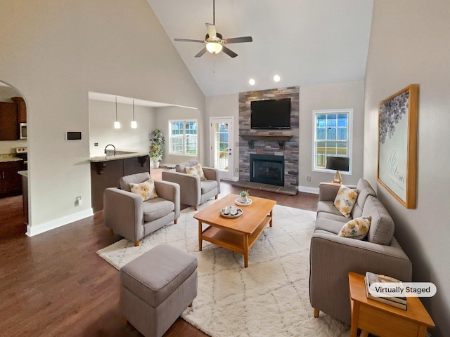 living room featuring ceiling fan, high vaulted ceiling, hardwood / wood-style floors, and a fireplace