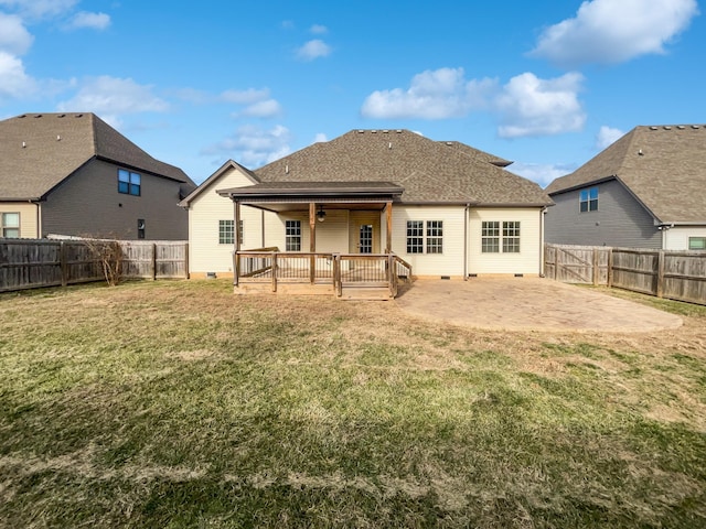 back of house featuring a deck, a patio, and a lawn