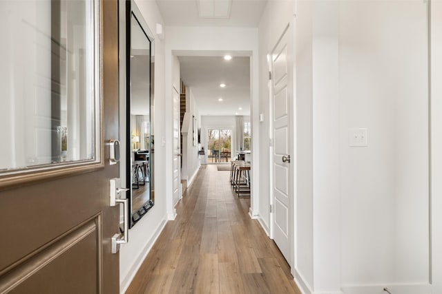 hallway with light hardwood / wood-style floors