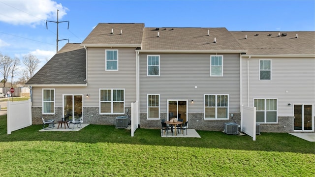 rear view of property featuring a yard, central AC unit, and a patio